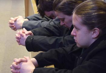 A family prays during the Mass. (Photo by John Simitz)