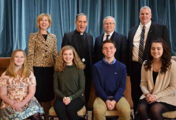 Overall division winners, Diocesan officials and guests are, from left: front, Chloe Palm-Rittle, first place Junior Division; Katie Hawkins, first place Senior Division; Andrew Hines, second place Junior Division; and Emily Carpenito, second place Senior Division; back, Mary Fran Hartigan, Father Bernard Ezaki, John Fitzpatrick and Philip Fromuth.