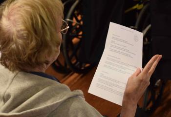 A resident at Holy Family Manor sings a hymn during Mass for World Day of the Sick.