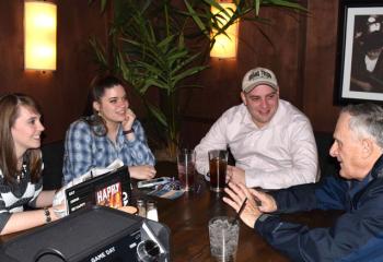 Father Frederick Riegler, right, chats with, from left, Alexa Doncsecz, Helen Smith and Brett Kita.