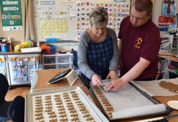 Betty Hader, left, volunteers her time at Mercy School for Special Learning, Allentown and makes gingerbread cookies with Mercy student Kyle Parker. (Photo by John Simitz)