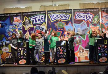 Glen Foster, left, host for “The Brain Show,” poses a question to students at St. Francis Academy, Bally during the interactive educational game. (Photo by John Simitz)