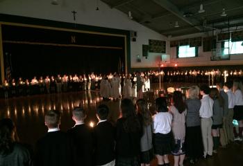 Students from Nativity BVM High School, Pottsville pray together by candle light after Bishop Alfred Schlert and local clergy processed into the school gymnasium for a CSW Mass. (Photo courtesy of Jessica Erdis)