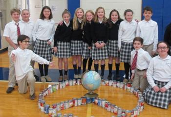 Fifth grade students from St. Michael the Archangel School, Coopersburg create a peace sign from soup cans they collected for “Souper Bowl.” The service project as part of CSW benefitted local food banks. (Photo courtesy Marianne Gano)