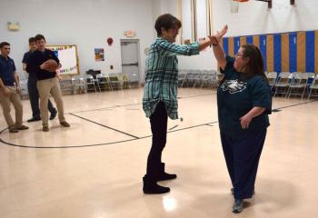 Patti Christoff, left, teacher’s aide at Mercy School for Special Learning, Allentown, exchanges a high-five with Mercy student Emily Quist after scoring a basket during a shoot-out with Notre Dame High School students. (Photo by John Simitz)