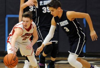 St. Thomas More’s Brendan Boyle (20) moves the ball by Andrew Rhein (3), Griffen Rhein (35) and Matthew Harley (33) of St. Ignatius Loyola, Sinking Spring during semi-finals March 4.  