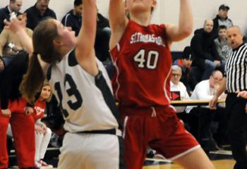 St. Thomas More’s Julia Roth (40) looks to shoot the ball past St. Patrick’s Jules Plachko (13) during the grade school girls’ championship.