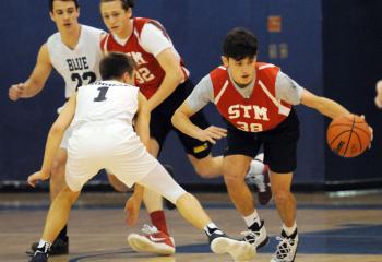 St. Thomas More’s Patrick Adams (38) drives past St. Joseph the Worker’s Sam Morgan (1). In back are St. Joseph the Worker's Shaun Coulter (22) and St. Thomas More’s Miles Wagner (32) during the high school boys’ championship game. 