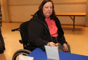 Joanne Olney learns about a relic on display at OLPH. 