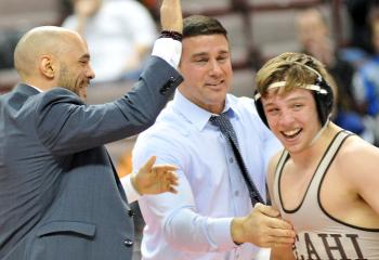 Ryan Anderson, right, celebrates with Becahi’s assistant coach Randy Cruz, left, and head coach Jeff Karam, becoming the school’s newest PIAA Class AAA state wrestling champion. Anderson captured the title by gaining a technical fall 20-4.