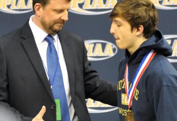 NDHS head wrestling coach John McGuire, left, congratulates his son, Ryan, before the 132-pound weight class medal ceremony at the PIAA Class AA mat tournament. McGuire finished fifth in the state. 