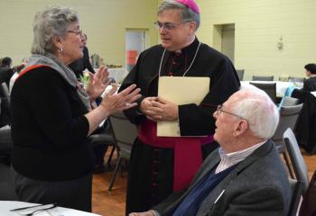 Bishop of Allentown Alfred Schlert speaks with Mary Ann and Randy Marshall, parishioners of St. Ann, Emmaus, at the kickoff. 