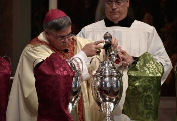 Bishop of Allentown Alfred Schlert, left, creates the Holy Oils March 29 by mixing oil from the balsam plant with olive oil before breathing on the mixed oil to signify the presence of the Holy Spirit, at the Diocesan Chrism Mass March 28 at the Cathedral of St. Catharine of Siena, Allentown