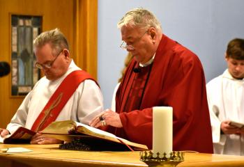 Father Joseph Whalen, right, pastor of St. Richard, Barnesville, leads the Celebration of Christ’s Passion on Good Friday, March 30. Assisting at the service is Deacon John Setlock, left. 