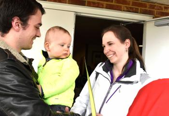 James Ludwig, center, admires a palm leaf held by his mother Megan Ludwig, along with his father Ryan Ludwig after observing the final Sunday of Lent and marking the beginning of Holy Week.