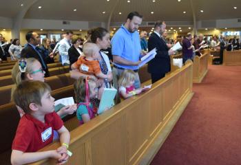 Members of the Morse family praying together at Mass are, from left: Aaron, Therese, Samantha, Tobias, mother Rebekah, Eve and father Tom. 