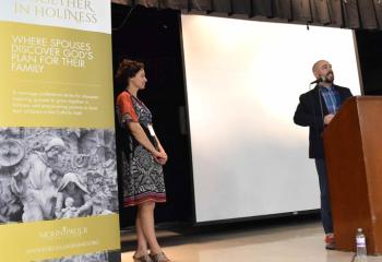 Dr. Joshua Schulz, right, and his wife, Christine Schulz, examine St. Pope John Paul II’s “Letter to Families” during the breakout session “Civilization of Love.”