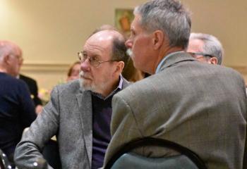 Guests listen to Bishop Alfred Schlert speak.