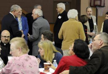 Clergy and faithful mingle at the kickoff of the appeal that hopes to generate $5 million. Seated at left is Father Jason Stokes, pastor of Most Blessed Trinity, Tremont.