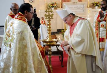 Bishop Schlert, right, lights a lamp with Father James Vattakunnel, director of Our Lady of Assumption Syro-Malabar Catholic Mission, Norwalk, Connecticut, as a symbol of God’s light in the world.