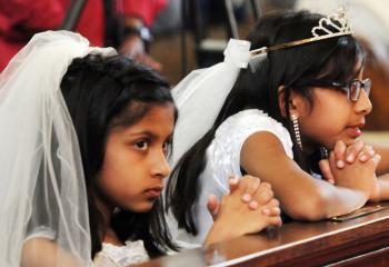 Leah Joseph, left, and her cousin Alina Joseph pray during the opening of the new center. 
