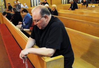 Praying the rosary are, from left, Nancy Steinmetz, Catherine Niedzwiecki and Monsignor Thomas Derzack.