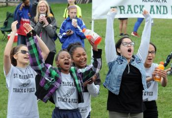 Girls from St. Margaret, Reading, from left, Jasmine Gonzalez, Shyra Fraziev, Ashley Charliez-Cruz, Angelina Gonzalez and Maurilenis Batista, cheer for their athletes running in a race. 