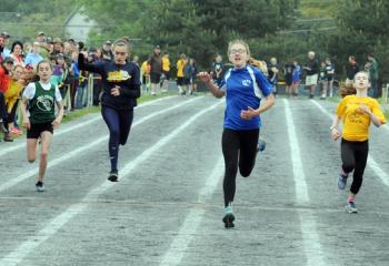 Alysha Gargone of Our Lady of Perpetual Help, Bethlehem, center, crosses the finish line to win the eighth-grade girls’ 400.