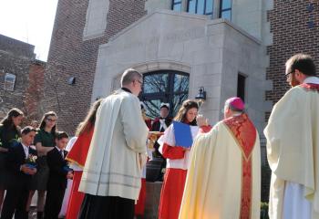 Bishop Schlert blesses the newly-renovated Bennett Building on the St. Jane School campus. Behind him are Father Kevin Lonergan, left, and Father David Anthony. 