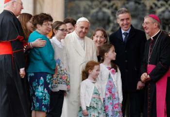 Pope Francis poses for a photo with a delegation of two Irish families led by Archbishop Diarmuid Martin of Dublin, right, during his general audience in St. Peter's Square at the Vatican March 21. Also pictured is Cardinal Kevin Farrell, left, prefect of the Dicastery for Laity, the Family and Life. Catholics who participate in the World Meeting of Families in Dublin in August or pray with their families during the Aug. 21-26 event can receive a plenary indulgence, the Vatican announced. (CNS photo)