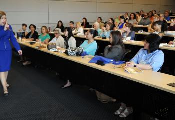 Lucia Baez Luzondo strolls across the room as she speaks to Spanish-speaking women. (Photo by Ed Koskey)