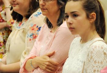 Magdalene Stratton, 16, left, her mother Deanna Stratton and sister Molly Stratton, 14, of Reading listen to Sister Faustina Maria Pia speak at the event. (Photo by Ed Koskey)