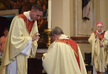Father Hutta, left, bestows his first priestly blessing on Bishop Schlert.