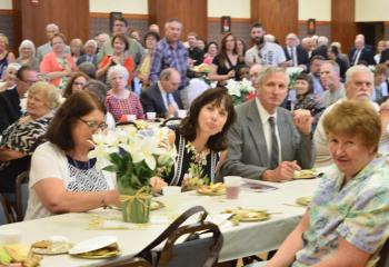 Clergy, family and friends celebrate the ordination of Father Hutta in the cathedral’s social hall.