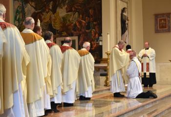 Monsignor William Glosser, pastor of St. Clare of Assisi, St. Clair and administrator of St. Stephen, Port Carbon, performs the Laying on of Hands to Father Hutta signifying oneness of the priesthood while priests wait in line to perform the same ritual.