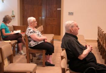 Praying with parishioners at Our Lady of Perpetual Help (OLPH), Bethlehem is Monsignor David Morrison. judge emeritus of the Diocesan Tribunal, in residence at OLPH. (Photo by Sue Braff)