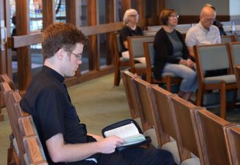 Father James Harper, assistant pastor of St. Thomas More, Allentown, prays with parishioners during adoration. (Photo by John Simitz)