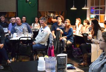 Young adults listen during “The Priest on the Bench: Stories of a Basketball Chaplain” at Hops at the Paddock, Allentown.