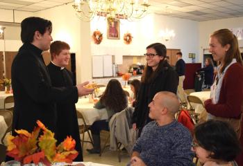 Seminarians Alexander Brown, left, and Tyler Loch chat with young adults at the social.
