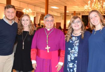 Bishop Schlert, center, enjoys time with students from DeSales. From left are Joseph Freemont, Angela Quaglio, Molly Cornish and Grace Hamilton.