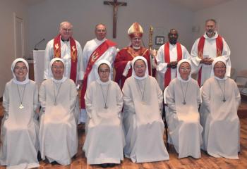 Bishop Alfred Schlert, back center, gathers after the liturgy with SAHS sisters and clergy, from left: front, Sister Mary Shalom Joo, Sister Mary John Park, Sister Mary Veronica Cho, Sister Mary Jerome Kim, Sister Mary Francesca Seo and Sister Mary Laudes Kim; back, Monsignor William Baker, Deacon James Warnagiris, Apostles of Jesus Father Barnabas Shayo and Father Francis Baransky.