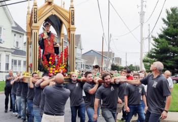 Joe Azzolina, left, and Placidino Rivilli, guide the society members hoisting the sixth century monk to avoid overhead electric and utility wires during the procession. 