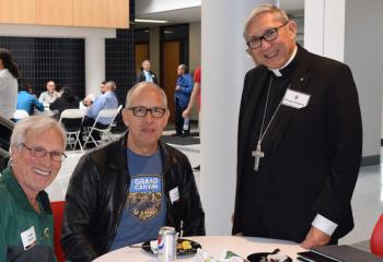 Bishop Cisneros, right, talks with Jerome Stephen, left and Salvador Espinosa during the lunch break.