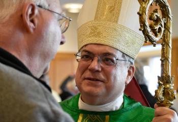 Bishop Schlert greets a conference participant after Mass.