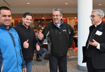 Men meeting Bishop Cisneros, right, at the Spanish-speaking track are, from left: Angel Martinez, Alberto Martinez and Felix Pereira.