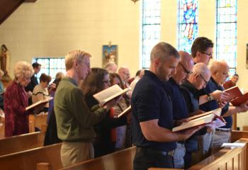 Members of Knights of Columbus Council 14924, seated in the front pew, recite prayers with the faithful during the Holy Hour at Assumption BVM. (Photo by John Simitz)