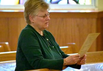 Angie Carlin prays during Benediction at Sacred Heart. (Photo by John Simitz)