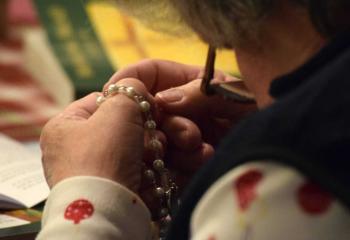 A woman prays a rosary during the day of reflection.