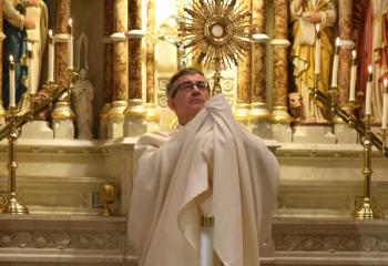 Father Dr. Robert Kosek, then pastor of St. John the Baptist, and of SS. Peter and Paul, Allentown, raises the monstrance during Eucharistic Adoration for more than 150 faithful. Father Kosek is now in congregational administrative service for the Barnabite order outside the Diocese of Allentown.