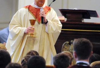 Father Searles talks with students about the vocation chalice that was donated for students to contemplate their vocation in life.